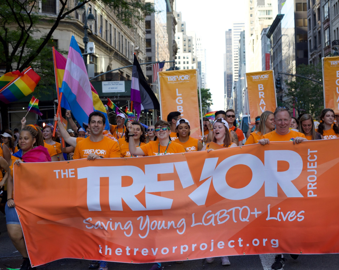 A public demonstration on the streets with flags about the Trevor Project and LGBTQ+ Pride