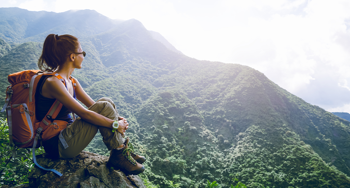 Woman hiker sitting enjoying a mountain view.